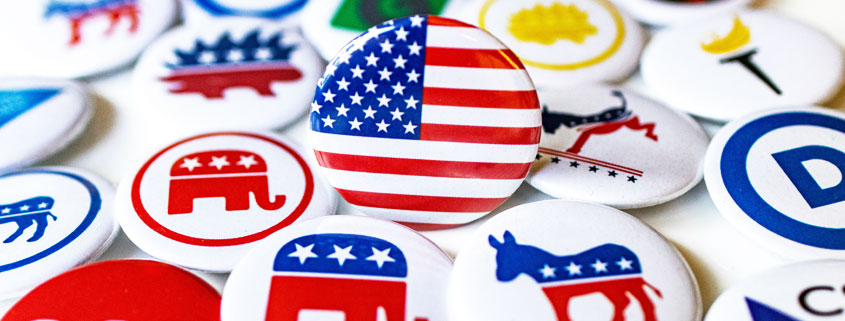 Collection of round American election campaign buttons featuring U.S. flags, stars, donkeys, elephants, and red, white, and blue political symbols