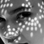 Black-and-white portrait of a woman's face showing her eyes, nose, lips, and prominent dark eyebrows