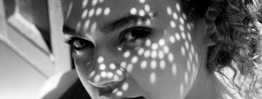 Black-and-white portrait of a woman's face showing her eyes, nose, lips, and prominent dark eyebrows