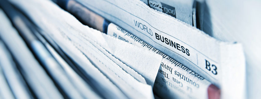 Multiple business newspapers arranged on a display stand, with one visible section labeled World Businesses B3
