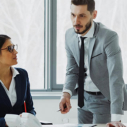 Businesswoman discussing reports with male and female colleagues seated around a table in a modern office