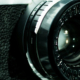 Camera lens with Canon and Bell and Howell branding visible on the equipment