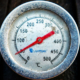 Analog temperature gauge mounted on black metal equipment with a Celsius scale ranging from 0 to 500 degrees