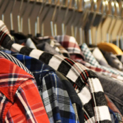 Colorful shirts neatly arranged on hangers along a clothing rack, displaying a variety of colors and styles in a retail fashion setting