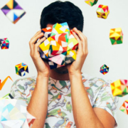 Person holding an intricate geometric paper sculpture made from interconnected folded shapes and cube-like structures