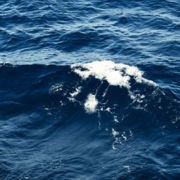 Deep blue ocean surface with powerful rolling waves and intense patterns of moving seawater