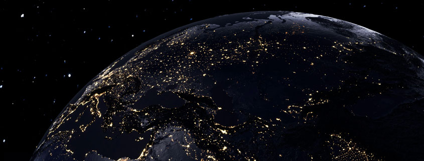 Planet Earth viewed from space at night, with glowing golden city lights illuminating parts of the globe against a dark, star-filled background