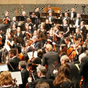 Musicians preparing for an orchestral performance before a large audience inside the Elbphilharmonie concert hall in Hamburg, Germany