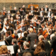Musicians preparing for an orchestral performance before a large audience inside the Elbphilharmonie concert hall in Hamburg, Germany