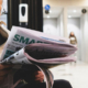 Elderly man wearing glasses and reading a newspaper with a serious, thoughtful expression