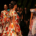 Group of glamorous fashion models walking along a runway in elegant outfits showcasing different clothing designs