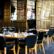 Elegant restaurant interior with clean, neatly arranged tables and chairs and employees working in the background