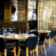 Elegant restaurant interior with clean, neatly arranged tables and chairs and employees working in the background