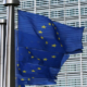 Multiple European Union flags displayed together featuring the blue background and circle of twelve gold stars