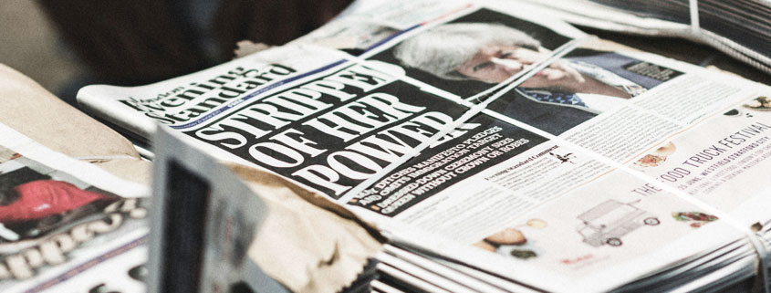 Bundles of freshly printed Evening Standard newspapers stacked on a London street, displaying headlines about political power struggles