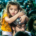 Man carrying a young girl on his shoulders amid a densely packed crowd of people in a busy public area