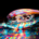 Light bulb glowing with multiple vibrant colors while resting on a colorful surface, symbolizing creative ideas