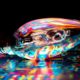 Light bulb glowing with multiple vibrant colors while resting on a colorful surface, symbolizing creative ideas