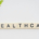 Healthcare sign positioned beside a curved green branch with fresh leaves