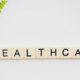 Healthcare sign positioned beside a curved green branch with fresh leaves