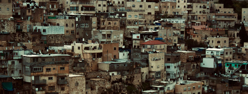 Hillside-Houses-Forming-a-Small-Residential-Town Cluster of houses built along a hillside, forming a compact residential community resembling a small town