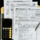 IRS Form 1040 and W-4 tax documents arranged on a clipboard with a calculator and pen
