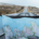 View from inside a car traveling along a road in Iceland, with an unfolded paper map resting on the dashboard for navigation