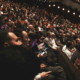Large audience gathered inside the Barbican Centre auditorium in London, United Kingdom, with rows of spectators filling the theater