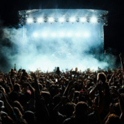 Group of performers gathered onstage during a live music concert or touring performance