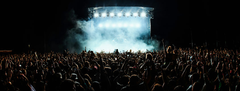 Group of performers gathered onstage during a live music concert or touring performance