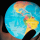 Man holding planet Earth in his hands with North America and South America facing forward