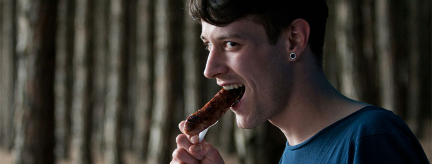 Man-Preparing-to-Take-a-Bite-of-Sausage Man with his mouth open, preparing to bite into a sausage
