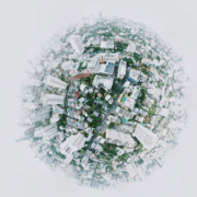Conceptual globe depicting a miniature world filled with houses, condominium buildings, and urban structures arranged across its spherical surface