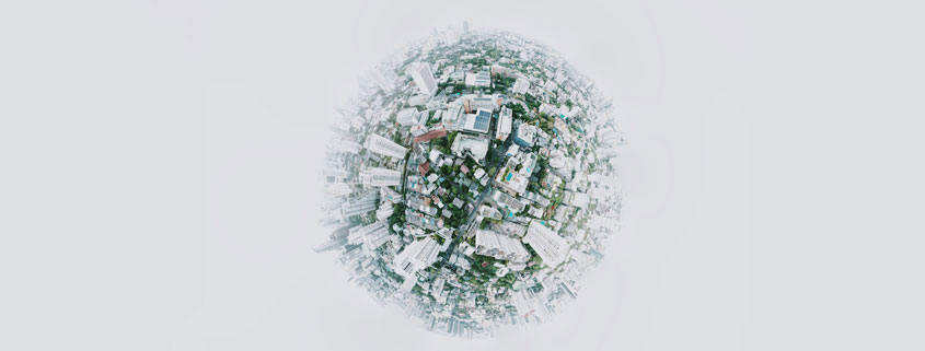 Conceptual globe depicting a miniature world filled with houses, condominium buildings, and urban structures arranged across its spherical surface