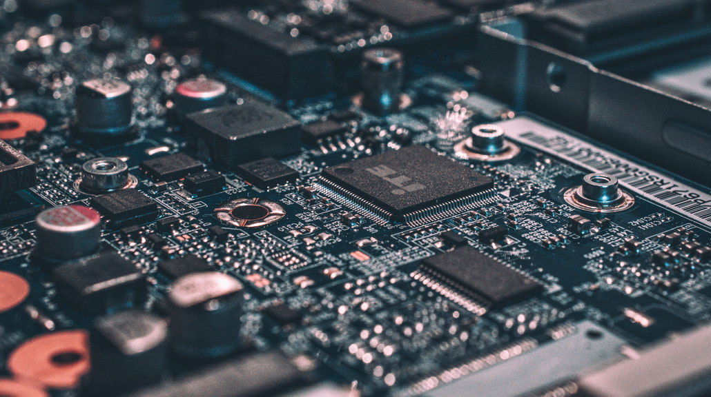 Detailed view of a clean laptop motherboard showing integrated circuits, microchips, connectors, and electronic components that power modern computing technology