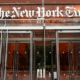 Main entrance to The New York Times building in New York City, featuring glass doors and The New York Times name displayed above the entrance