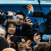 Journalists and television reporters surrounding a person on Capitol Hill with cameras and microphones during a news interview