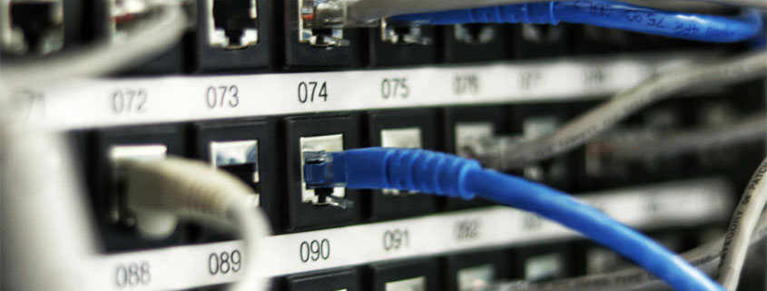 Numbered-Network-Ports-With-Connected-Ethernet-Cables Ethernet network cables connected to numbered ports on networking equipment used for server and network communications