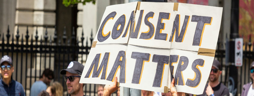 Protest-Rally-Sign-Reading-Consent-Matters Hands holding a sign reading Consent Matters during a public protest rally