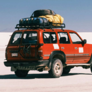 Red Toyota truck on the Salar de Uyuni salt flats in Bolivia with travel equipment secured to its roof