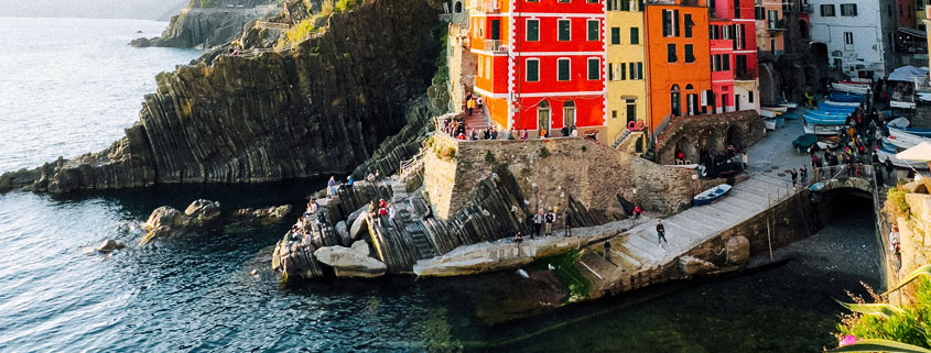 Colorful waterfront houses in Riomaggiore, Cinque Terre, Italy, overlooking the clear blue waters of the Ligurian Sea