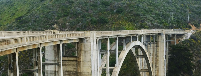 Scenic-Bridge-Along-Monterey-California-Coast Scenic bridge near Monterey, California, surrounded by the natural landscape of the Pacific Coast