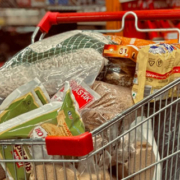 Shopping cart filled with groceries and everyday food products during a supermarket shopping trip