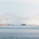 Cargo ship approaching the Suez Canal suspension bridge in Egypt, with the vessel visible in the distance along the waterway
