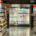 Supermarket aisle displaying a variety of food products including cheese, dairy items, candy, cookies, and biscuits