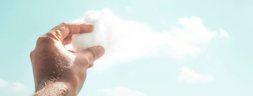 The-Middle-Space-Where-Creativity-Actually-Forms Human hand reaching into the sky and grasping the edge of a white cloud in a surreal creative composition