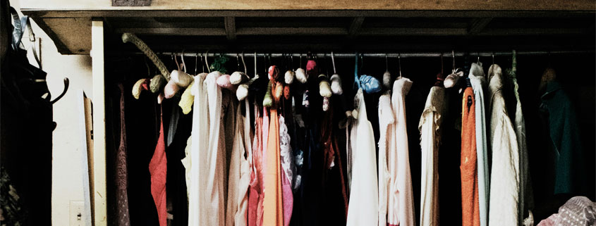 The-Stretch-That-Ate-the-Wardrobe Wardrobe filled with vintage women's clothing and dresses hanging together in a collection of traditional fashion styles