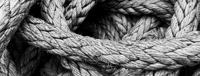 Thick-Rope-Loosely-Coiled-in-a-Pile Thick rope gathered into a loose pile with overlapping loops and visible slack