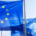 Three European Union flags displaying a circle of twelve yellow stars against a blue background