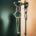 Two metal keys connected by a keychain, with one key inserted into a door lock and the other hanging below